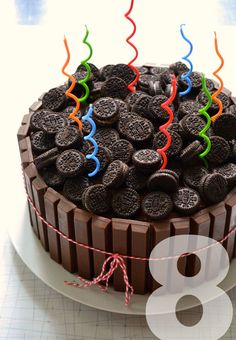 a chocolate cake with oreo cookies on top and streamers in the shape of birthday candles