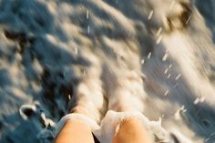 someone is standing in the snow with their feet up and there are white powder on them