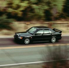 a black car is driving down the road