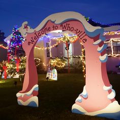 christmas lights decorate the front yard of a house with an archway that reads welcome to willow