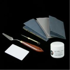 the contents of a crafting kit including paint, paper and scissors on a black background