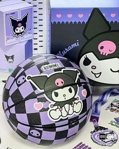 a purple and black ball sitting on top of a table next to some stickers