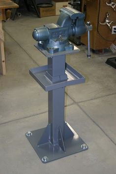 a machine that is sitting on top of a metal stand in a room with other tools