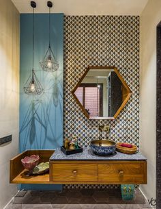 a bathroom with a sink and mirror next to a wall mounted light hanging from the ceiling