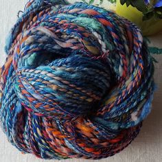 a ball of yarn sitting on top of a table next to a potted plant