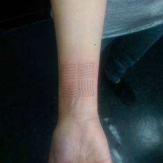 a person's arm with a small dot pattern on the left side of their wrist