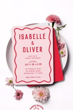 a pink and red wedding card next to some flowers on a plate with the words igabella & oliver