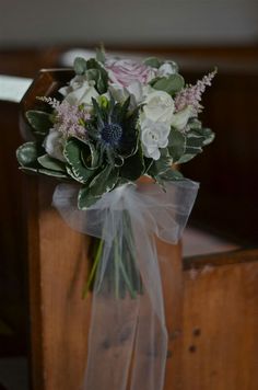 a bouquet of flowers sitting on top of a wooden bench