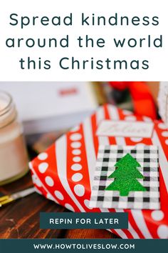 a christmas present sitting on top of a wooden table next to a jar of candles