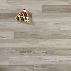 a wooden floor with a triangle shaped candy box on it's side and several candies in the middle