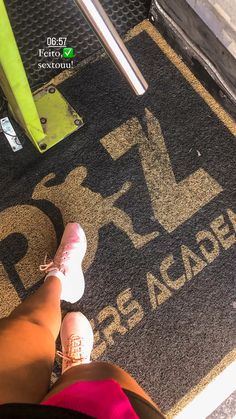 the feet of a person standing in front of a sign