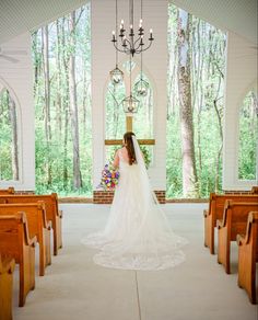 the bride is walking down the aisle in her wedding dress at the alter to the church