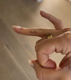 a woman's hand with a tiny ring on her finger and the word love written on it