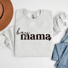 a white shirt with the word boy mama on it next to jeans and a hat