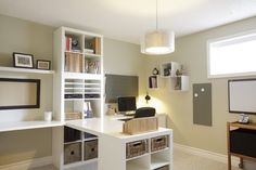 a home office with white desk and shelves