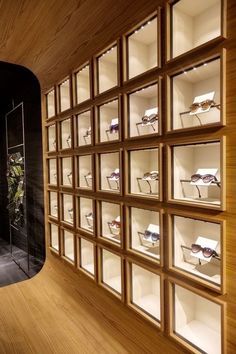 a display case filled with lots of different types of glasses on shelves next to a wall