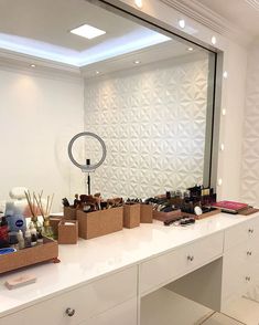 a white counter topped with lots of boxes filled with makeup and personal care items in front of a large mirror