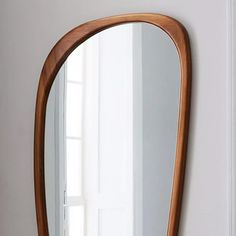 a large wooden mirror hanging on the wall