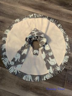 a white and gray table cloth on top of a wooden floor with an umbrella in the middle