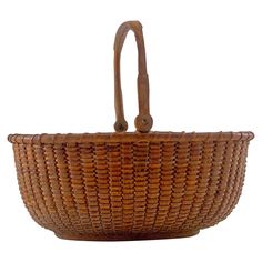 a brown wicker basket with leather handles on a white background for use as a purse or tote bag