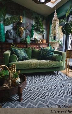 a living room filled with green furniture and lots of plants on top of the walls