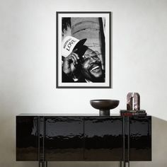 a black and white photo hanging on the wall next to a sideboard in a living room