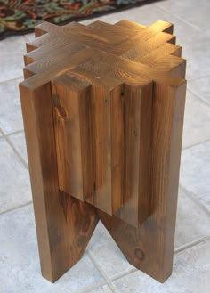 a wooden table that has been made into a sculpture with multiple sections cut out and placed on the floor