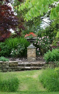 a stone pillar in the middle of a garden