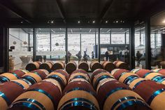 many wine barrels are lined up in a room