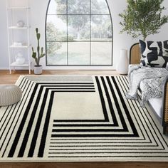 a black and white area rug in front of a large window with potted plants