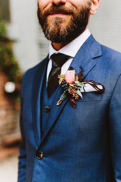 a man in a blue suit with a flower on his lapel