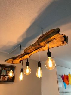 some light bulbs are hanging from a wooden beam