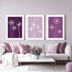 three purple and white paintings in a living room