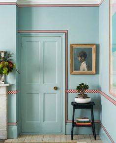 a blue door in the corner of a room next to a table with a potted plant on it