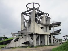 an unusual building sits on the side of a dirt road with stairs leading up to it