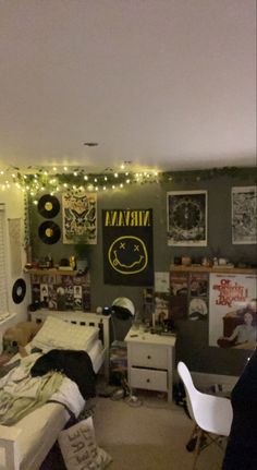 a dorm room with lights strung from the ceiling and pictures on the wall above it