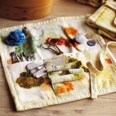 a table topped with lots of crafting supplies on top of a wooden table next to scissors