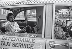 two men sitting in the back seat of a taxi