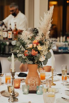 the table is set with flowers and candles