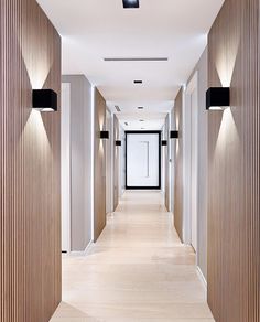 the hallway is lined with wooden panels and black lights on either side of the door