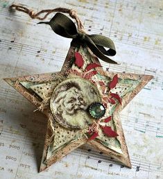 a christmas star ornament with a santa clause on it's face hanging from a string