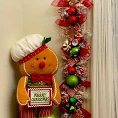 a christmas decoration with a teddy bear next to a tree and decorations on the wall