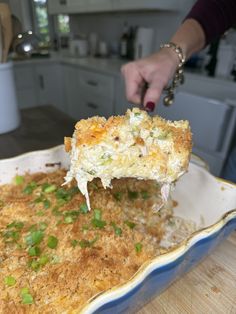 a person scooping some food out of a casserole dish