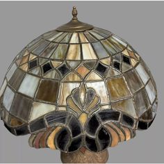 a stained glass lamp with an ornate design on it's top and bottom part