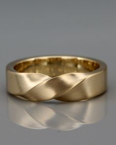 a gold wedding band that has been made to look like a wavy wave on it