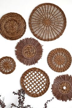 wicker wall hangings with woven circles on the side and flowers in the foreground