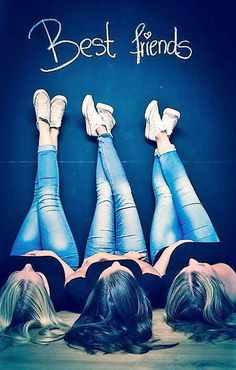 three women laying down on the ground with their feet up in front of them, both wearing blue jeans and white shoes