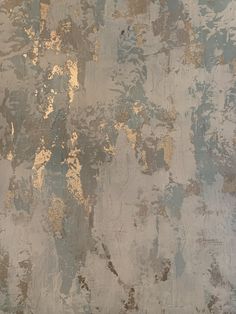 an old wall that has been painted gold and silver with paint chippings on it