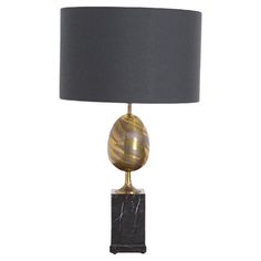 a table lamp with a marble base and grey lampshade on the bottom, along with a black shade