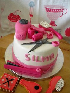 there is a cake with pink decorations on it and scissors, combs, and other items